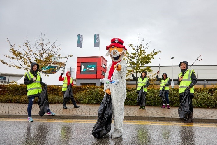 A womble with volunteer litter pickers at Lakeside Village